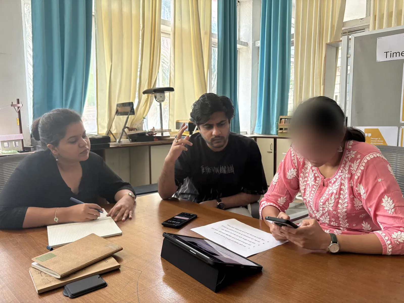 A participant typing on the test phone while teammates take notes